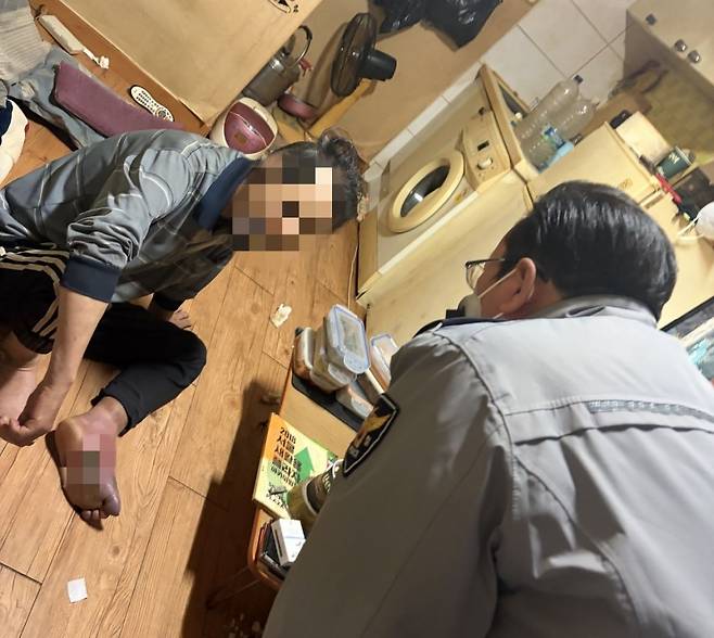 서울 독산파출소 소속 고병진(54) 경감이 지난달 3일 독산동의 한 다세대주택에서 정모(68)씨를 만나 치료 받을 것을 설득하고 있다. 고병진 경감 제공