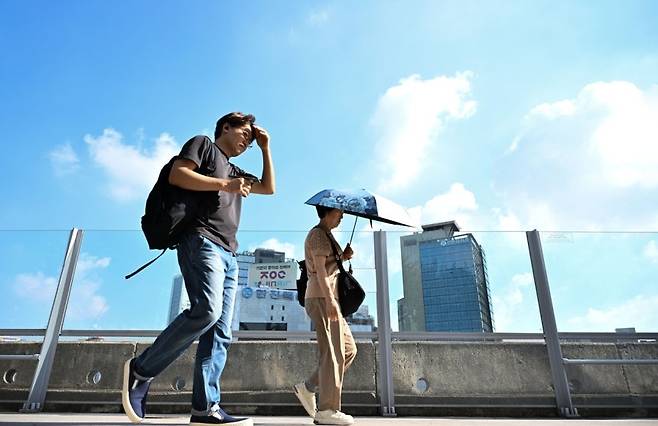 해당 사진은 기사 본문과 관계없습니다. 서울 중구 서울로7017 고가교에서 시민들이 양산과 손으로 얼굴을 가리며 지나고 있다. 임세준 기자