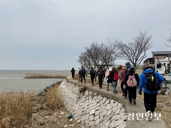 지난 11일 정기 모임에서 강화 남단 갯벌 옆으로 지나는 강화나들길 제8코스를 걷고 있는 사단법인 강화나들길 회원들. 2026.3.11 /박경호기자 pkhh@kyeongin.com