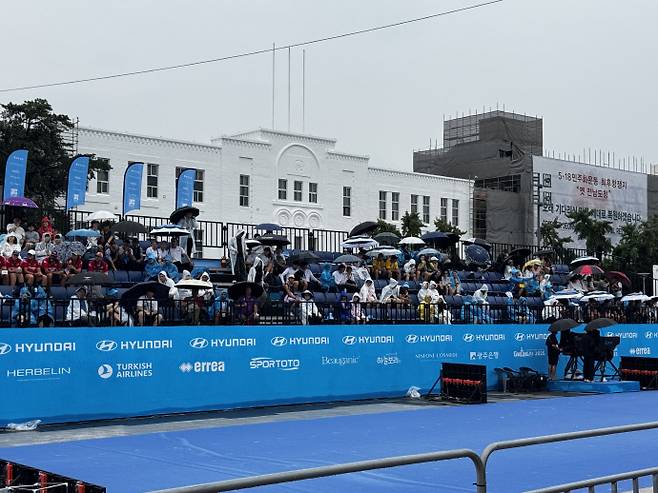 경기장 중앙에 자리한 관계자석과 카메라석에는 천장이 설치돼 비를 피할 수 있었지만, 시민이 앉은 관중석에는 비를 막을 천장이 없어 미리 자리에 앉은 시민들이 고스란히 비를 맞았다. /임지섭 기자 ljs@namdonews.com