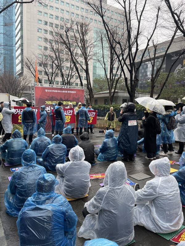 18일 한국거래소 서울사옥 앞에서 열린 '거래 시간 연장 중단을 위한 증권 노동자 결의대회'에서&nbsp;증권노동자들이 오전 7시 거래시간 연장을 반대하는 퍼포먼스를 하고 있다. [출처= 남영재 기자]