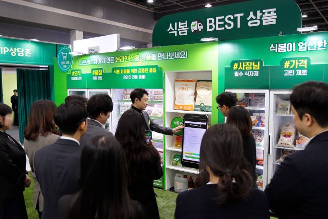 18일 오전 서울 양재 aT 센터에서 개최된 '푸드 솔루션 페어 2026'을 찾은 관람객들이 온라인 식자재 유통 플랫폼 '식봄'에 대한 설명을 듣고 있다.(사진제공=CJ프레시웨이)