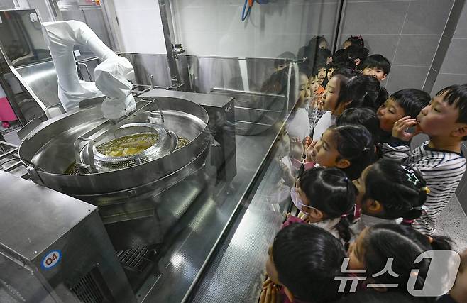 18일 경기 수원시 장안구 대평초등학교 내 위치한 거점형 학교급식 튀김 지원실에서 1학년 학생들이 튀김 조리 로봇이 직접 가동되는 현장을 보고 있다. (공동취재) 2026.3.18 ⓒ 뉴스1 김영운 기자