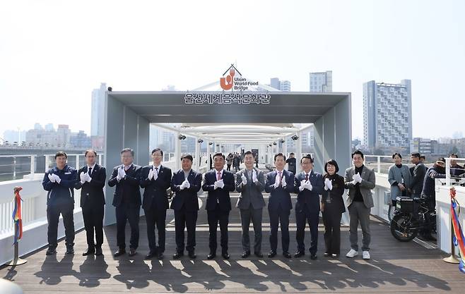 태화강 전망과 도심 야경을 즐길 수 있는 울산교에 세계 각국의 음식을 맛볼 수 있는 ‘세계음식문화관’이 문을 열어 시민들의 호응을 얻고 있다. 김두겸 울산시장(왼쪽에서 다섯번 째)과 이성룡 울산시의회 의장(왼쪽에서 네번 째), 김영길 울산 중구청장(왼쪽에서 여섯번 째) 등 관계자들이 10일 열린 개관식에서 기념촬영을 하고 있다. 울산시 제공