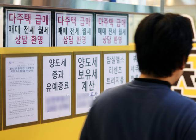 17일 서울 시내의 한 공인중개사 사무소 앞을 시민들이 지나가고 있다. 뉴스1