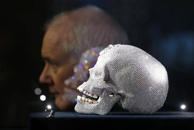 영국 작가 데이미언 허스트가 20일부터 서울 종로구 국립현대미술관에서 열리는 아시아 최초 대규모 개인전 ‘진실은 없어 그러나 모든 것은 가능하지’를 앞두고 18일 가진 기자간담회에서 8,601개 다이아몬드가 백금 두개골을 장식한 작품 '신의 사랑을 위하여'를 배경으로 포즈를 취하고 있다. 뉴시스