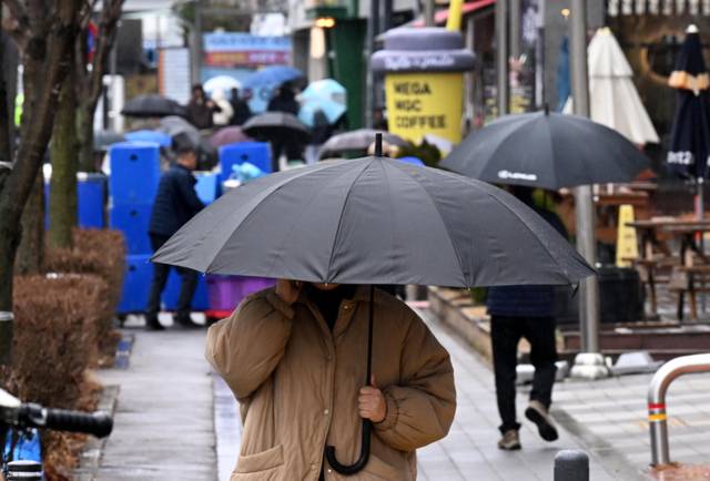 ▲ 봄을 재촉하는 비가 내린 2일 춘천 온의동에서 우산을 쓴 시민들이 발걸음을 옮기고 있다. 김정호 기자