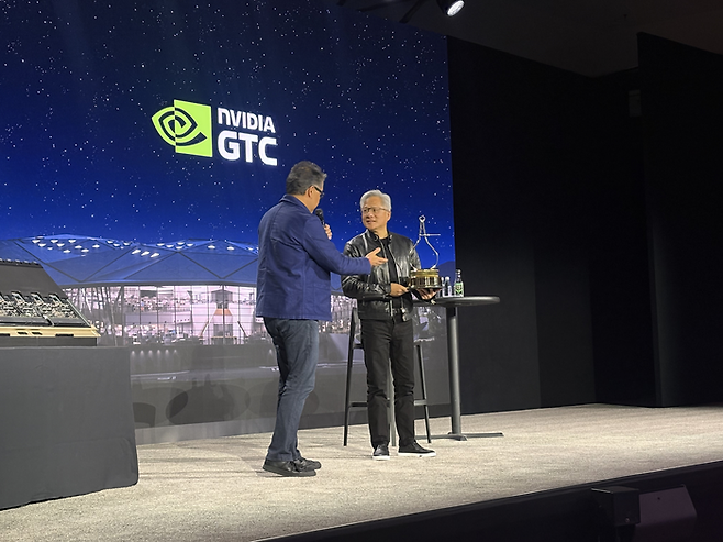 17일 GTC2026에서 열린 글로벌 기자간담회에서 모토트렌드 기자가 “올해의 인물로 젠슨 황 엔비디아 CEO가 선정됐다”라며 트로피를 전달하고 있다. [사진=원호섭 특파원]