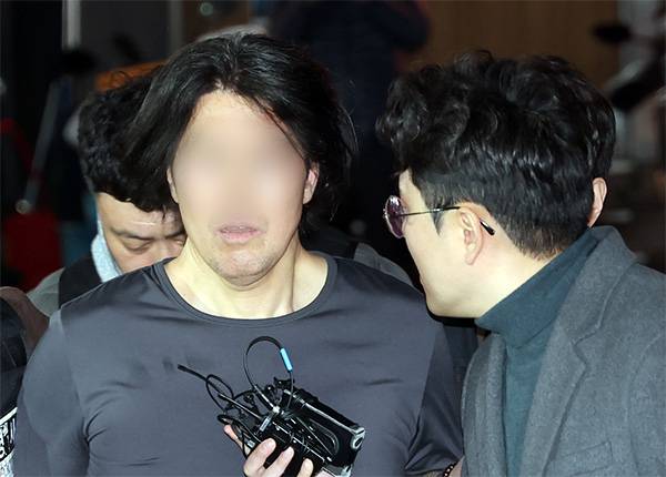 부산에서 전 직장 동료인 항공사 기장을 흉기로 살해한 혐의를 받는 50대 A씨가 17일 부산 부산진경찰서로 압송되고 있다. [뉴시스]