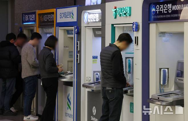 [서울=뉴시스] 조성우 기자 = 인터넷전문은행의 수수료 지원금을 노려 하루에 최소 50여회, 최대 600여회나 현금을 반복 인출한 혐의를 받는 결제대행업체(VAN) 기기 가맹점주들에게 벌금형이 확정됐다. 사진은 서울 시내의 한 건물에서 시민들이 시중은행 ATM기기를 이용하는 모습. 2026.03.18. xconfind@newsis.com *사진은 기사 내용과 무관함.