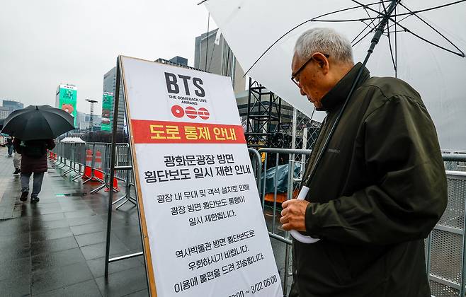 방탄소년단(BTS)의 광화문 컴백 공연을 앞둔 18일 서울 종로구 광화문광장에서 한 시민이 도로 통제 안내문을 살펴보고 있다.