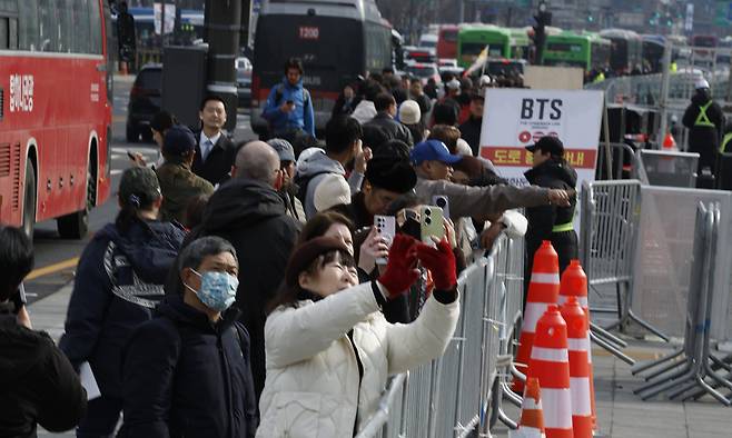설레는 팬심 방탄소년단(BTS)의 광화문 컴백 공연을 사흘 앞둔 18일 서울 종로구 광화문광장 일대가 통제된 가운데 시민들이 펜스 너머의 공연 현장을 스마트폰으로 촬영하고 있다. 정부는 이날 서울 종로구·중구 일대의 테러 경보 단계를 ‘관심’에서 ‘주의’로 한 단계 상향 조정했다. 유희태 기자