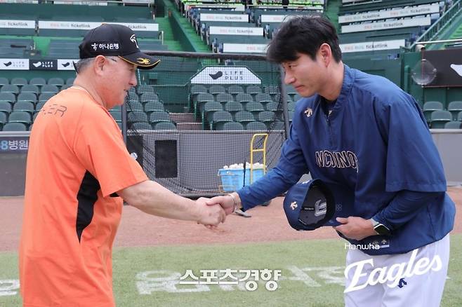 김경문 한화 감독(왼쪽)이 부임한 2024년 6월 NC와 첫 만남에서 강인권 당시 NC 감독과 악수하고 있다. 둘은 두산과 NC 시절 감독과 코치로 긴 인연을 맺고 있다. 한화이글스 제공