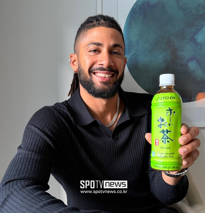 ▲ 페르난도 타티스 주니어가 2026 WBC 공식 후원사 이토엔의 녹차 제품을 들고 있다. 도미니카공화국 선수들은 기자회견장에 놓인 이 음료를 테이블 밑으로 치우거나, 마시다 뱉어냈지만 타티스 주니어는 "전화해요"라며 광고 모델을 자처했다.