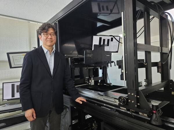 정진만 아이비젼웍스 전무가 지난 10일 검사 장비 앞에서 기념촬영을 하고 있다. [출처=진운용 기자]