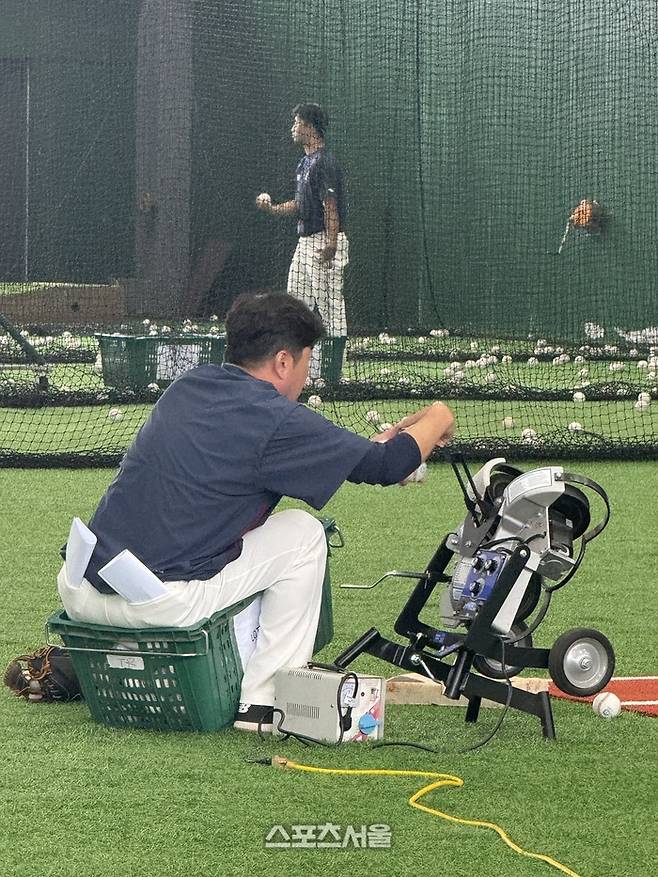 문규현 코치가 쭈그리고 앉아서 기계에 공을 넣고 있다. 타이난 | 박연준 기자 duswns0628@sportsseoul.com