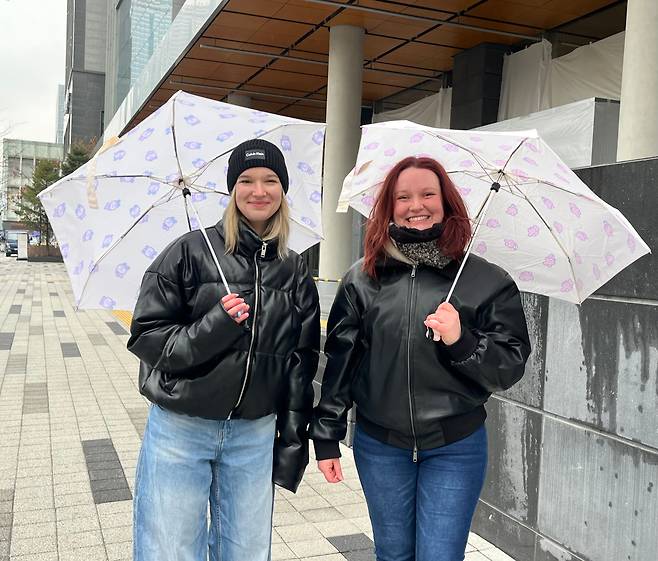 18일 서울 용산구 하이브 사옥 앞에서 만난 독일인 자매 리나(24)·줄리아나 크르스테(26)가 BTS 캐릭터가 그려진 우산을 들고 웃고 있다./김진영 기자