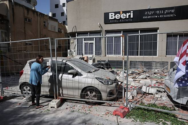 18일(현지시간) 이스라엘 라마트간에서 이란의 집속탄이 주택을 타격해 이스라엘인 부부가 사망한 현장을 시민들이 바라보고 있다. AP=연합뉴스