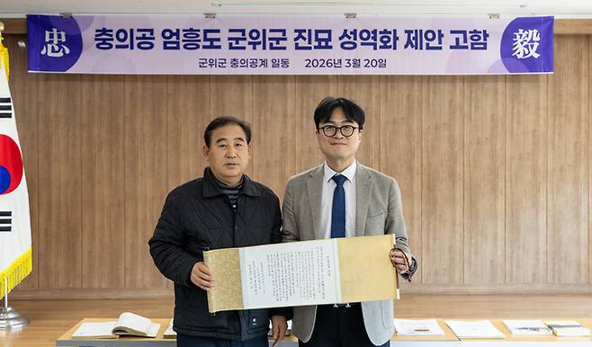 ▲ 엄흥도 문중 대표 20대손 종손 엄근수(왼쪽) 씨가 20일 군위군 산성면사무소 회의실에서 열리는 '충의공 엄흥도 군위군 진묘 성역화 제안' 행사에서 이재성(오른쪽) 군위부군수께 충의공 엄흥도 군위군 진묘 성역화 제안 고함이라는 전문을 전달한 후 기념촬영을 하고 있다. 박용덕 군위군향토사위원 제공