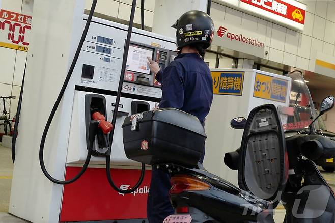 18일(현지시간) 일본 도쿄의 한 주유소에서 한 남성이 오토바이에 기름을 넣고 있다. 2026.03.18. ⓒ AFP=뉴스1