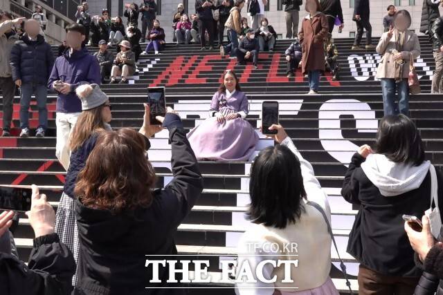 방탄소년단(BTS)의 컴백 공연을 하루 앞둔 20일 서울 광화문광장에서 외국인 관광객이 BTS 관련 홍보물 앞에서 사진을 찍고 있다. /광화문=김민지 기자