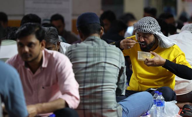 지난 14일 아랍에미리트(UAE) 두바이의 한 모스크에서 해가 저문 뒤 하루 동안의 라마단 금식을 마치는 이프타르 행사에 참석한 신자들이 식사를 하고 있다. /EPA 연합뉴스