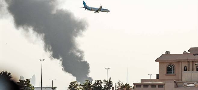 AFP 연합뉴스또 공격받은 두바이 공항  16일 이란의 드론 공격으로 연기에 휩싸인 아랍에미리트(UAE) 두바이 국제공항 상공에서 항공기가 착륙을 준비하고 있다. 아랍에미리트는 미국·이스라엘의 공격 이후 주변 국가를 겨냥한 이란의 반격이 집중된 곳이다.