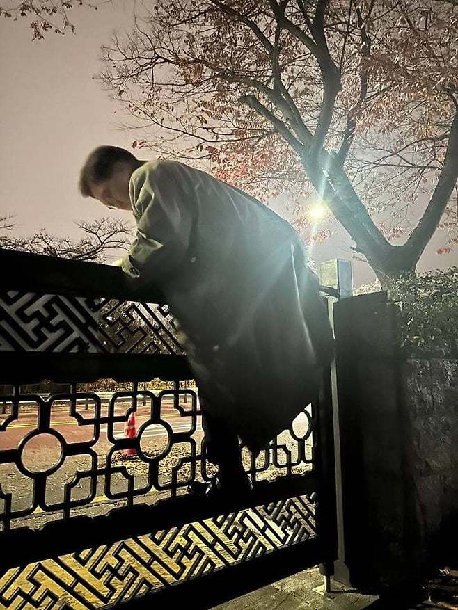 2024년 12월 3일 오후 11시경 대통령 비상계엄으로 경찰이 통제 중인 서울 여의도 국회에서 우원식 국회의장이 담을 넘어 본청으로 향하는 모습. 국회의장실 제공