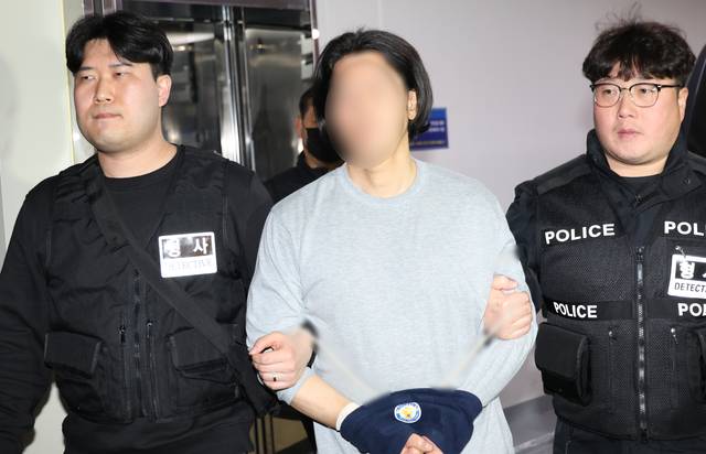 항공사 기장을 흉기로 살해한 50대 김모씨가 20일 부산 부산진경찰서에서 구속 전 피의자 심문(영장실질심사)에 출석하기 위해 이동하고 있다.  [연합뉴스]