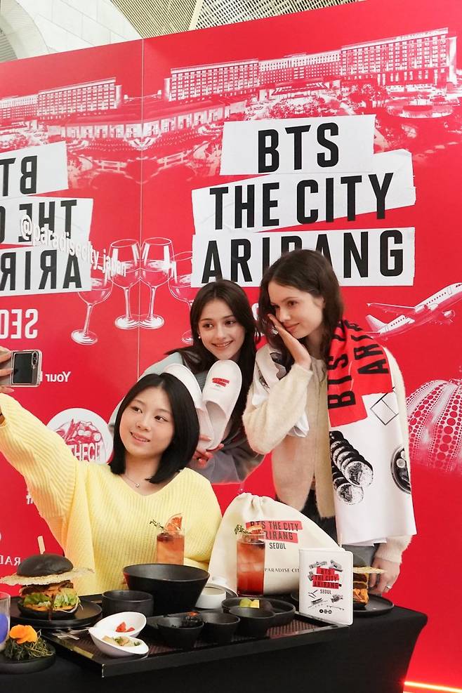 20일 파라다이스시티 플라자에 조성된 포토존에서 모델들이 BTS 컴백을 기념하는 한정판 굿즈와 BTS 테마 '블랙버거' 등 다양한 식음메뉴를 소개하고 있다. 사진=뉴스1