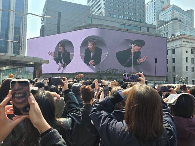 서울 중구 신세계백화점 본점 외벽 미디어 파사드에 20일 오후 1시 방탄소년단(BTS) 신곡 '스윔(SWIM)' 뮤직비디오가 공개되자 팬들이 휴대폰으로 영상을 촬영하고 있다. 김준형 기자