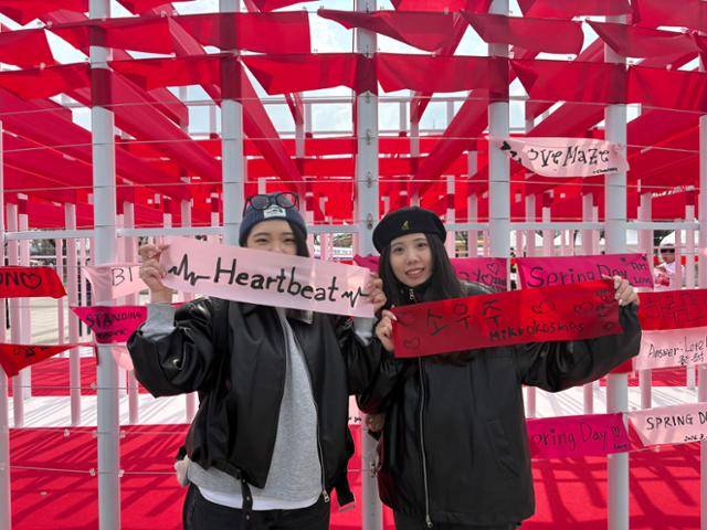 20일 서울 여의도공원에 마련된 방탄소년단(BTS) 체험 행사장 '러브 송 라운지'에서 대만팬 온우위(32)와 멍제이(32)가 천으로 된 방명록에 글을 남긴 뒤 기념촬영을 하고 있다. 전예현 기자