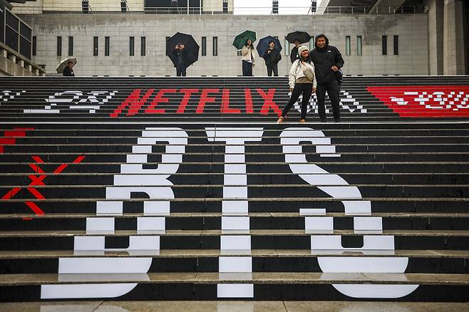 BTS 서울 광화문광장 컴백 공연을 앞둔 18일 서울 종로구 세종문화회관 계단을 찾은 외국인 팬들이 BTS 랩핑 앞에서 사진을 찍고 있다. /뉴시스