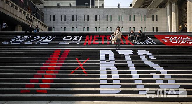 [서울=뉴시스] 정병혁 기자 = 방탄소년단(BTS)의 서울 광화문광장 컴백 공연을 앞둔 17일 서울 종로구 세종문화회관 계단을 찾은 일본인 팬들이 방탄소년단 랩핑 앞에서 사진을 찍고 있다. 2026.03.17. jhope@newsis.com