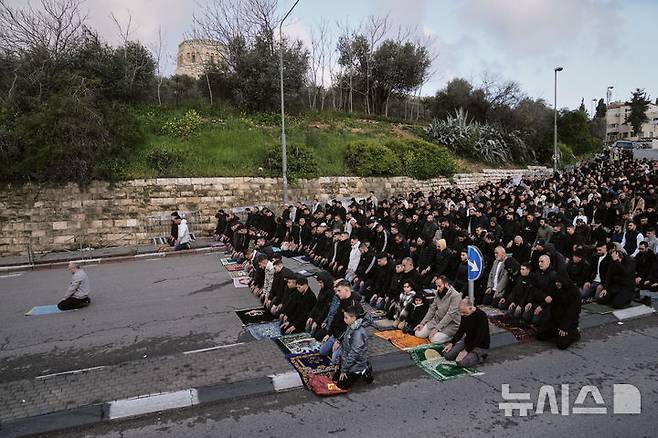 [AP/뉴시스] 라마단 종료로 시작된 이슬람 에이드 알피트르 축일 첫날인 20일 이스라엘 당국의 동예루살렘 구시가지 봉쇄 지속으로 알아크사 모스크에 들어가지 못한 무슬림들이 인근 길바닥에서 예배 기도를 하고 있다