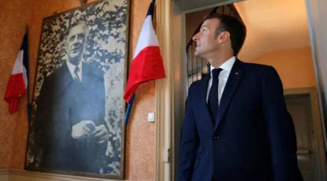 샤를 드골 장군(왼쪽 사진)의 생가를 방문한 에마뉘엘 마크롱 프랑스 대통령이 고인의 사진을 쳐다보고 있다. AFP연합뉴스