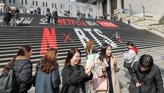 방탄소년단(BTS)의 서울 광화문광장 컴백 공연을 하루 앞둔 20일 서울 종로구 세종문화회관 계단에서 외국인 관광객들이 기념촬영을 하고 있다.