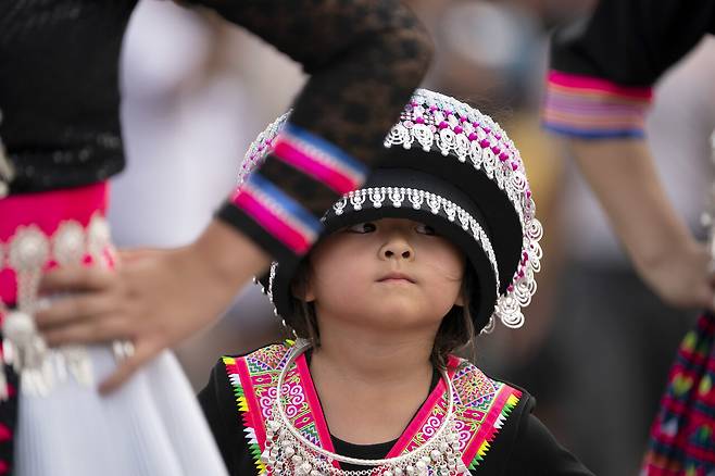 몽족 전통 의상을 입은 한 어린이가 2021년 미국 미네소타에서 열린 퍼레이드에 참석했다. 베트남전쟁 이후 미국은 미군을 도운 몽족을 난민으로 받아들였다. ⓒAP Photo