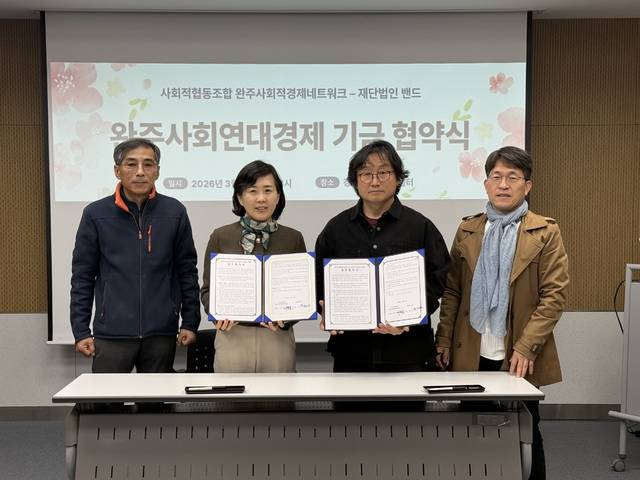 완사넷 박용범 이사장(왼쪽부터 3번째)과 밴드 김선영 이사가 업무협약을 체결한 후 협약서를 들어 보이고 있다.완사넷