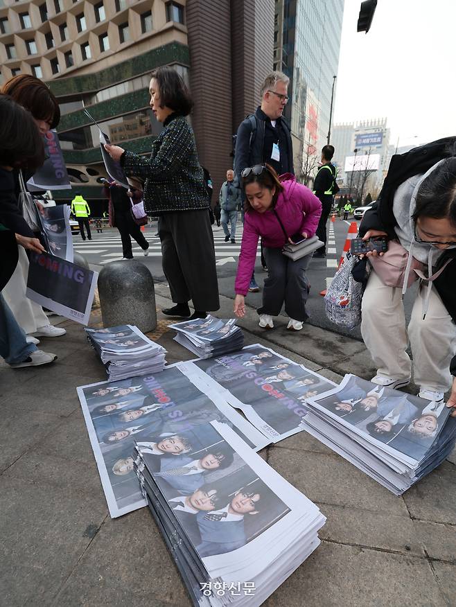 방탄소년단(BTS)의 컴백 공연을 보기 위해 한국은 찾은 외국인 팬들이 21일 서울광장에서 경향신문이 특별판으로 제작해 배포한 ‘BTS 굿즈’를 집어들고 있다. 강윤중 기자