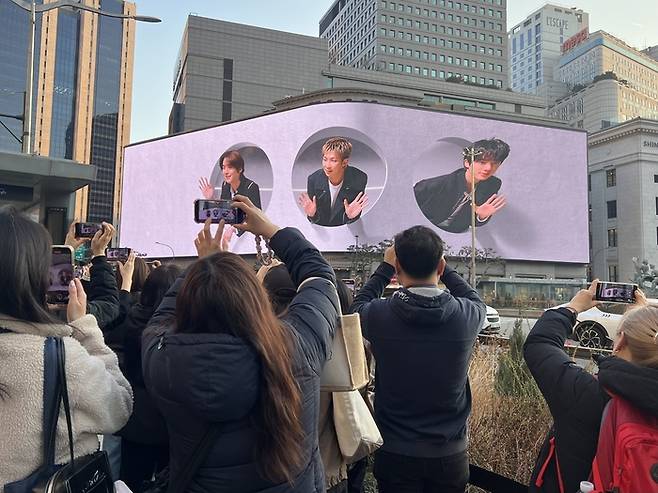 신세계백화점 본점 외벽에 걸린 초대형 전광판에는 방탄소년단(BTS)의 컴백을 기념해 영상이 송출된다. 사진은 관광객들이 미디어 파사드 영상을 촬영하는 모습. (이채원 기자)