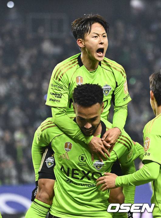 [OSEN=전주, 박준형 기자] 18일 전북 전주월드컵경기장에서 '하나은행 K리그1 2026'&nbsp;전북 현대와 FC안양의 경기가 진행됐다.  FC안양은 개막 3경기 무패로 상승세를 이어가고 있고 3위에 랭크됐다. 반면 디펜딩 챔프 전북 현대는 시즌 첫 승을 위해 3전 4기에 도전한다.후반 전북 현대 이승우가 역전골 넣은 모따의 등에 업혀 기뻐하고 있다.  2026.03.18 / soul1014@osen.co.kr