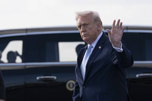 20일(현지시간) 미국 백악관을 떠나 플로리다주 팜비치 공항에 도착한 도널드 트럼프 대통령이 전용기에서 내려 리무진으로 이동하며 사람들에게 손을 흔들고 있다. AFP연합뉴스