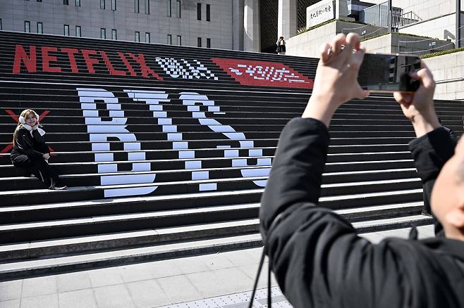 방탄소년단(BTS) 컴백 공연을 이틀 앞둔 19일 서울 종로구 세종문화회관 계단에 설치된 BTS 컴백 공연 관련 설치물에서 팬들이 추억을 남기고 있다. 조태형 기자