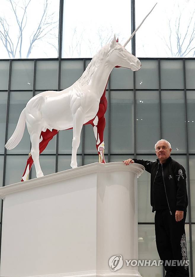 유니콘과 포즈 취하는 데이미언 허스트 (서울=연합뉴스) 이재희 기자 = 영국 작가 데이미언 허스트가 18일 서울 종로구 국립현대미술관에서 열린 '진실은 없어 그러나 모든 것은 가능하지' 개인전에 전시된 '신화' 작품 앞에서 포즈를 취하고 있다. 2026.3.18 scape@yna.co.kr