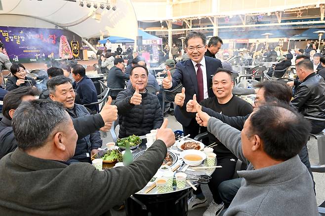 ▲ 김진열 군위군수가 20일 군위전통시장 야시장을 찾은 방문객과 즐거운 한때를 보내며 엄지척을 외치고 있다. 군위군 제공