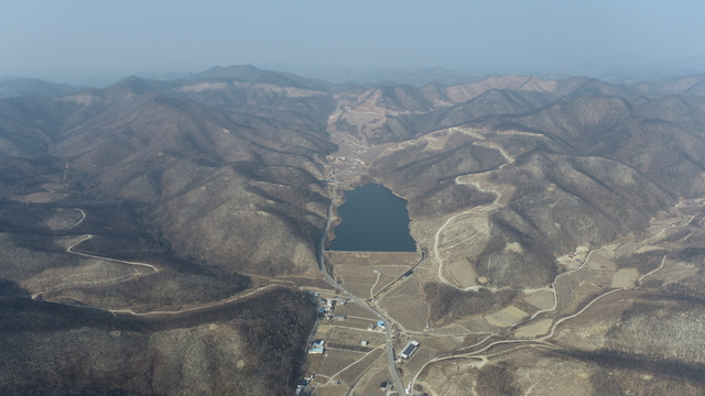 ▲ 의성군 점곡면 동변리 산림경영특구 대상지 일대에서 산불 피해 산림과 저수지 주변 전경이 내려다보이고 있다. 의성군 제공