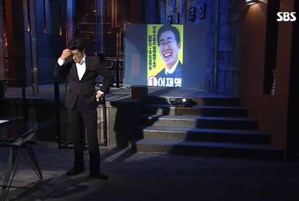 이재명 대통령의 성남 조폭 연루설을 보도한 SBS '그것이 알고 싶다'&nbsp;2018년 7월 21일자 '권력과 조폭 - 파타야 살인사건 그 후 1년' 방송의 한 장면.&nbsp;진행자인 김상중 씨가 "이재명 변호사 이름이 등장해 당혹스럽다"며 한숨을 쉬고 머리를 짚고 있다.&nbsp;'그것이 알고 싶다' 다시 보기 화면 갈무리