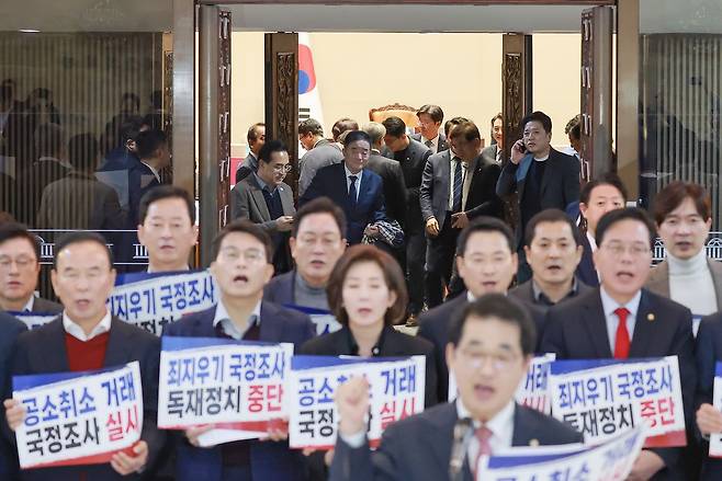 박홍근 기획예산처 장관 후보자 등 더불어민주당 의원들이 22일 국회 본회의장에서 나오는 가운데 국민의힘 장동혁 대표 등 의원들이 국회 로텐더홀에서 윤석열 정권 시절 검찰의 조작기소 의혹에 관한 국정조사' 추진을 규탄하고 있다. 연합뉴스