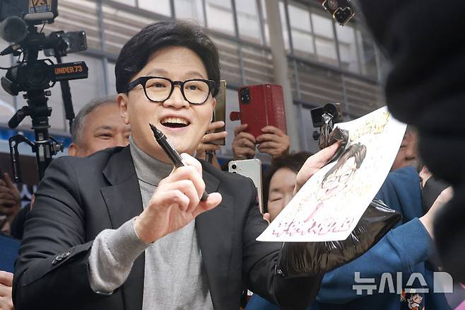 [서울=뉴시스] 정병혁 기자 = 한동훈 전 국민의힘 대표가 22일 서울 동대문구 경동시장을 찾아 시장상인에게 사인을 해주고 있다. (공동취재) 2026.03.22. photo@newsis.com